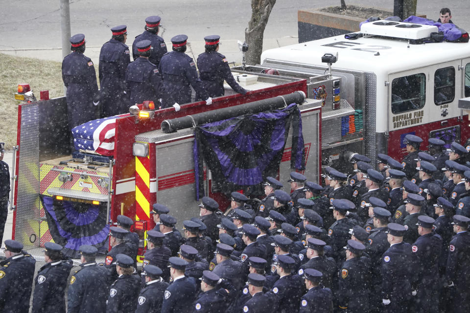 Engine Two carries the casket of fallen Buffalo Firefighter Jason Arno past rows of saluting firefighters and first responders as the procession arrives for the Mass of Christian Burial at St. Joseph Cathedral in Buffalo, N.Y., on Friday, March 10, 2023. The 37-year-old father who had been with the department for three years was killed in an explosive blaze. (Derek Gee/The Buffalo News via AP)