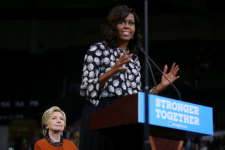 U.S. Democratic presidential candidate Hillary Clinton listens as U.S. First Lady Michelle Obama speaks during a campaign rally in Winston-Salem, North Carolina, U.S., October 27, 2016. REUTERS/Carlos Barria