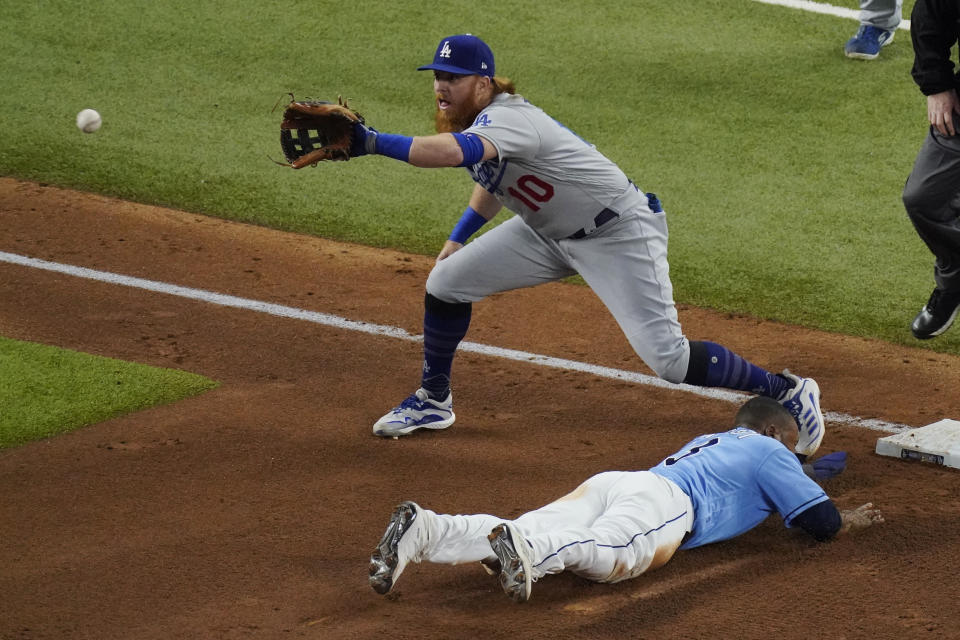 Tampa Bay Rays' Manuel Margot is safe at third past Los Angeles Dodgers third baseman Justin Turner after a Los Angeles Dodgers fielding error by Chris Taylor during the fourth inning in Game 5 of the baseball World Series Sunday, Oct. 25, 2020, in Arlington, Texas. (AP Photo/Sue Ogrocki)