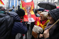 A man kisses a banner with the colors of the Spanish flag and a religious image during a police protest in Madrid, Spain, Saturday, Nov. 27, 2021. Tens of thousands of Spanish police officers and their supporters rallied in Madrid on Saturday to protest against government plans to reform a controversial security law known by critics as the “gag law.” (AP Photo/Paul White)