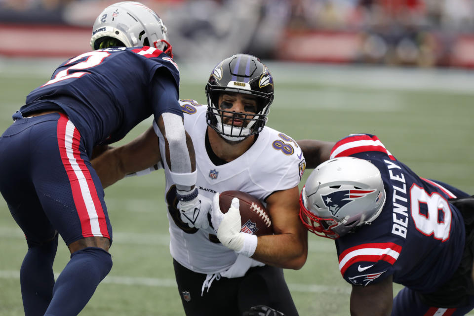 Baltimore Ravens tight end Mark Andrews, center, is brought down by New England Patriots cornerback Jalen Mills, left, and linebacker Ja'Whaun Bentley, right, in the first half of an NFL football game, Sunday, Sept. 25, 2022, in Foxborough, Mass. (AP Photo/Paul Connors)