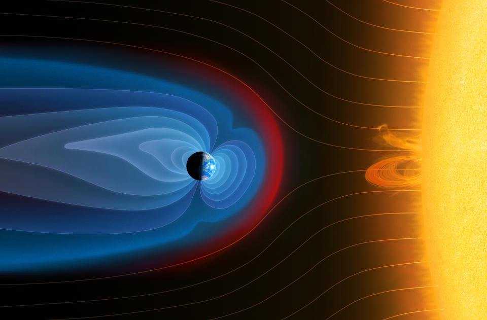 wavy blue lines surround the Earth and repel red lines representing the solar wind flowing from the sun