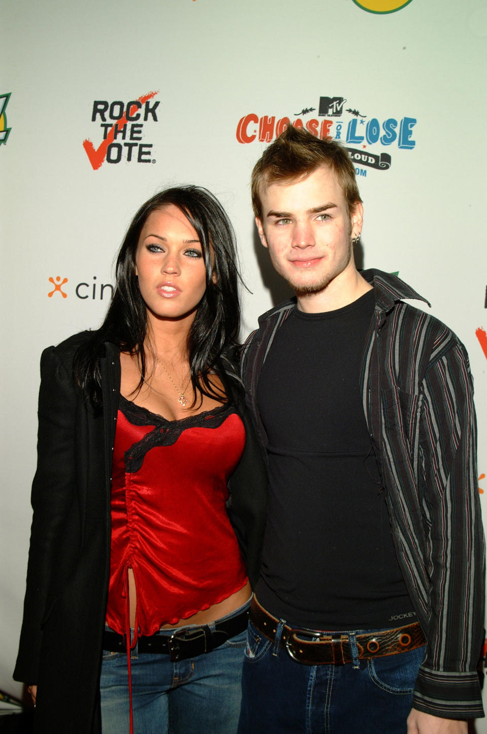 Megan in a black blazer, red top, and jeans and David in a striped shirt and jeans at a Rock the Vote event