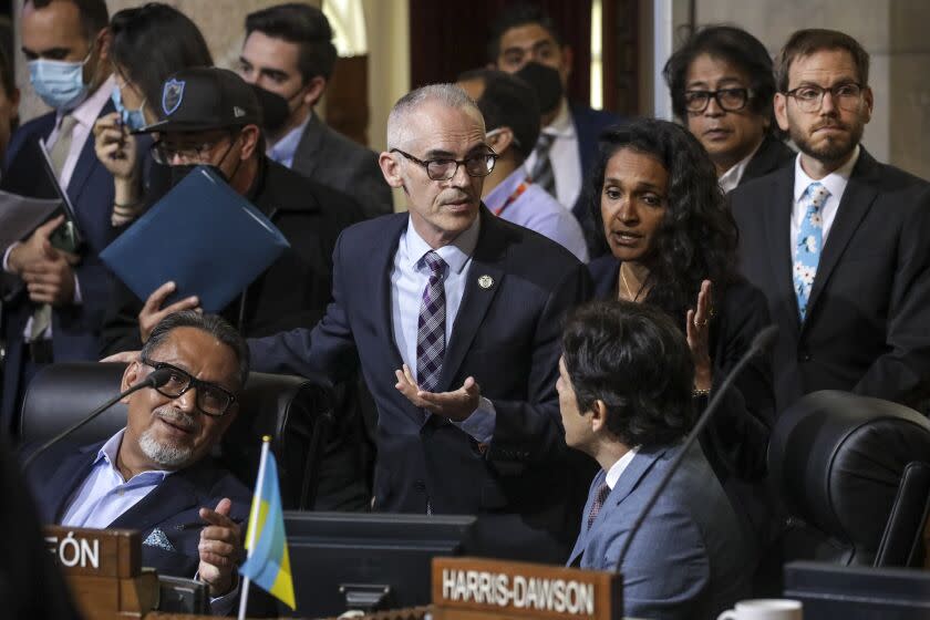 Los Angeles, CA - October 11: Acting council president Mitch O'Farrell, standing left, and Councilwoman Nithya Raman talk to council members Gil Cedillo, left, and Kevin de Leon who are under pressure from public to leave the meeting and resign. City Hall on Tuesday, Oct. 11, 2022 in Los Angeles, CA. (Irfan Khan / Los Angeles Times)