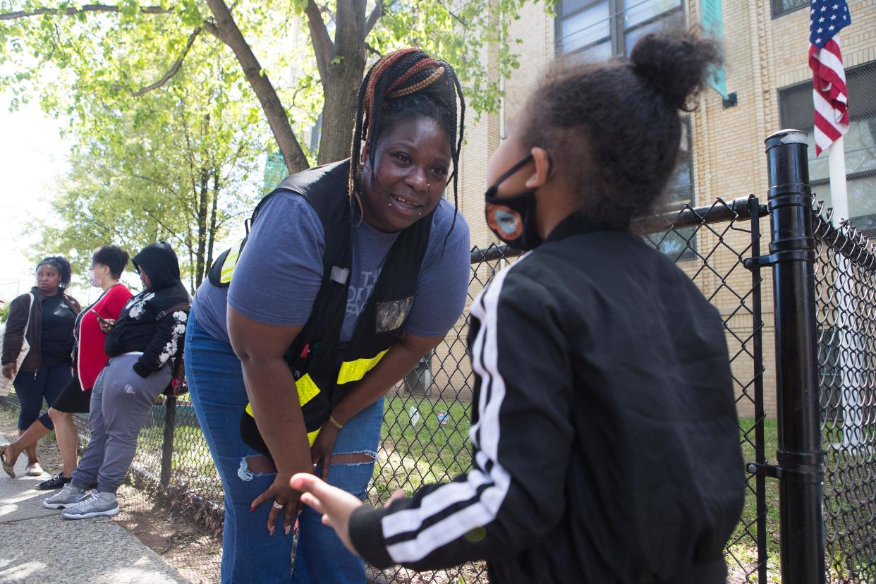 Newark Community Street Team member Sameerah Johnson speaks with a student after school Wednesday, May 11, 2022, in Newark N.J.