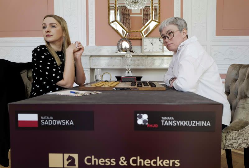 Draught players Polish Natalia Sadowska and Russian Tamara Tansykkuzhina look on before a game during the Women's World Draughts Championship in Warsaw