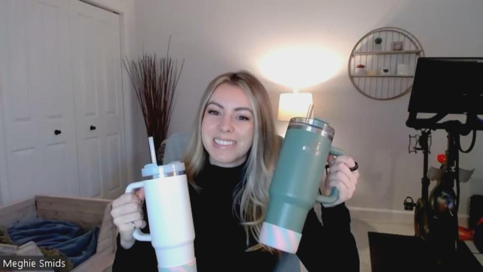 Meghie Smids, a Canadian influencer, holds up her Stanley water bottles. Smids says the unique colours and the ability to fit in a cup holder are what initially attracted her to the bottles. 