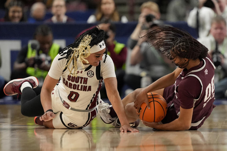 South Carolina guard Te-Hina Paopao and Texas A&M guard Sydney Bowles vie for the ball during the first half of an NCAA college basketball game at the Southeastern Conference women's tournament Friday, March 8, 2024, in Greenville, S.C. (AP Photo/Chris Carlson)