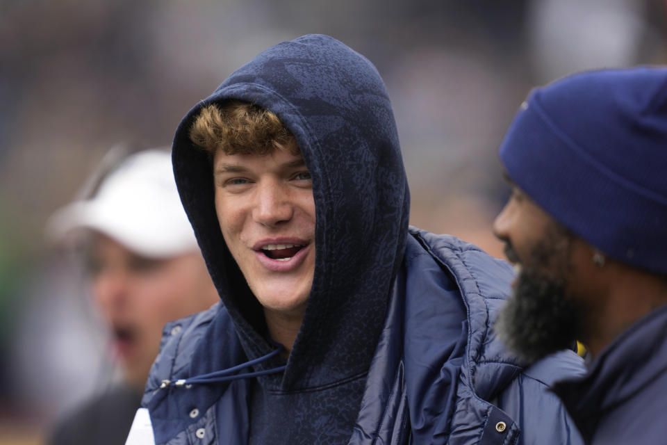 Former Michigan quarterback J.J. McCarthy talks with former defensive back Charles Woodson during the NCAA college football team's spring game in Ann Arbor, Mich., Saturday, April 20, 2024. (AP Photo/Paul Sancya)