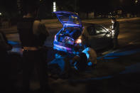 Police officers arrest three men suspected of setting a bushfire, in the Paris suburb of Villiers-le-Bel, Tuesday, June, 15, 2021. After being called out to help deal with a fire, night patrols stopped a vehicle carrying young men they suspected may have been involved in setting the blaze. The young men waited patiently and quietly on a roadside kerb until officers let them go. (AP Photo/Lewis Joly)