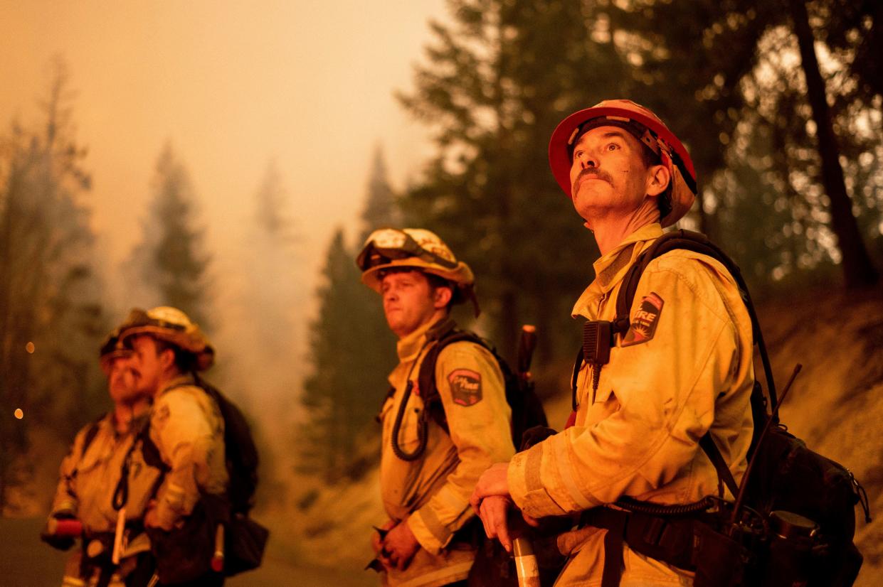 Cal Fire Capt. Dom Kaska, right, monitors flames as his crew burns vegetation to stop the Dixie Fire from spreading near Prattville in Plumas County, Calif. on Friday, July 23, 2021.