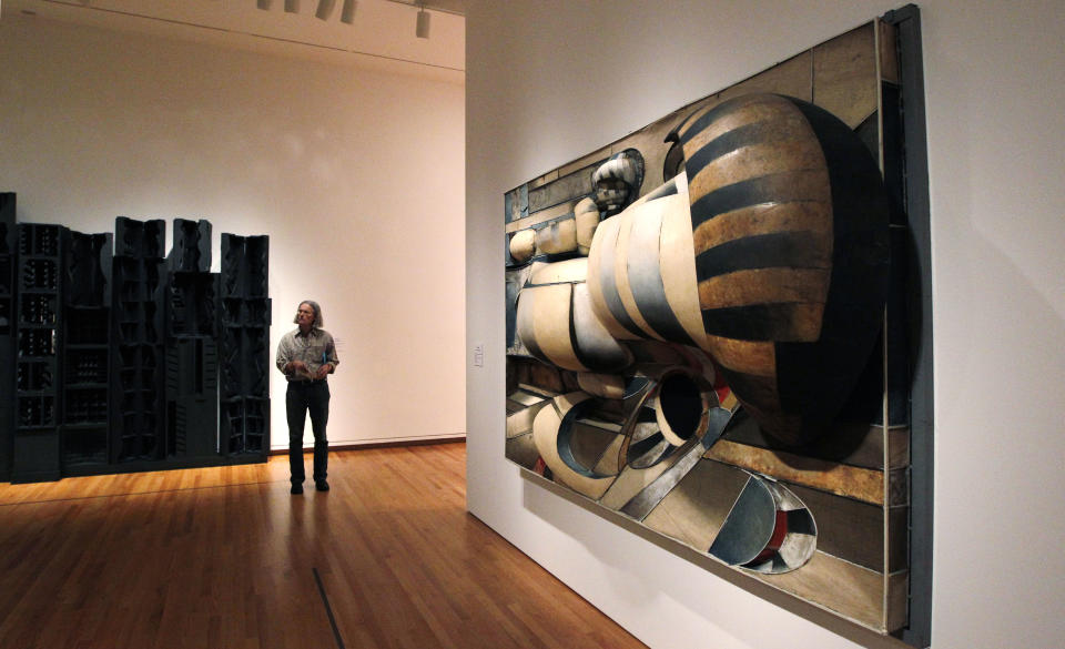 In this photo taken Tuesday, Oct. 9, 2012, a visitor stands near an untitled work by Lee Bontecou, right, part of one of two new exhibits featuring art exclusively by women at the Seattle Art Museum, in Seattle. Included in the exhibition is the only U.S. stop for an exhibit from the Pompidou Center in Paris, home of the modern art museum there, of painting, sculpture, drawing, photography and video. The exhibit runs through Jan. 13, 2013. (AP Photo/Elaine Thompson)