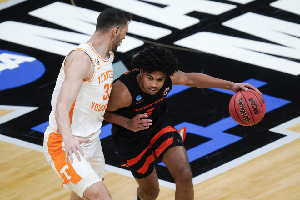 Oregon State guard Ethan Thompson (5) drives on Tennessee forward Uros Plavsic (33) during the first half of a first round game at Bankers Life Fieldhouse in the NCAA men's college basketball tournament in Indianapolis, Friday, March 19, 2021. (AP Photo/Paul Sancya)