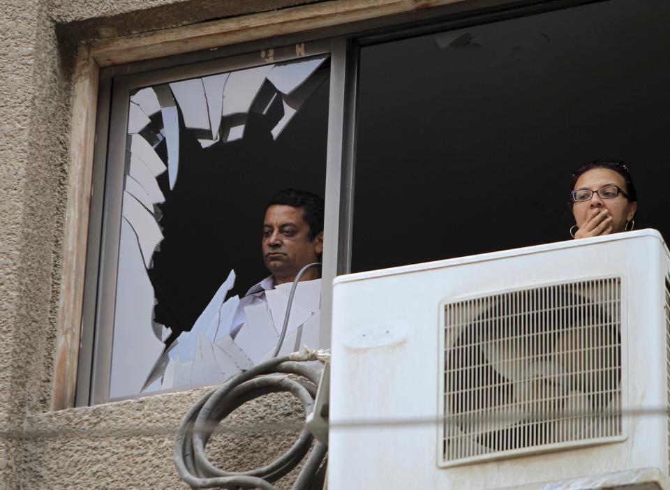 Residents look at the site of a car bomb attack on the convoy of Egyptian public prosecutor Hisham Barakat near his house at Heliopolis district in Cairo