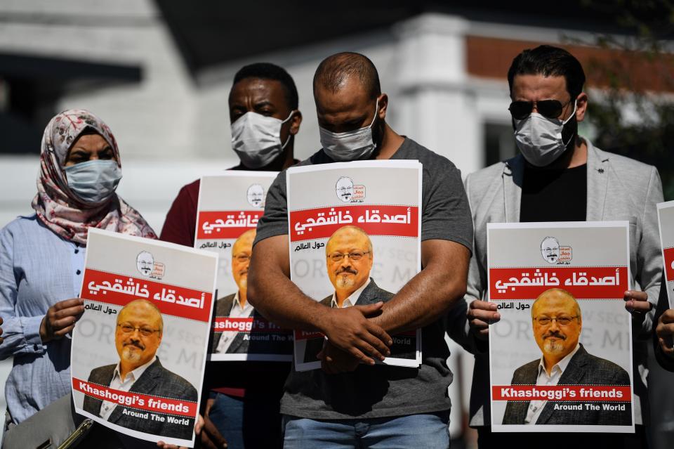 People hold posters bearing Khashoggi's picture at an Oct. 2, 2020, event marking the second-year anniversary of his death. (Photo: OZAN KOSE/AFP via Getty Images)