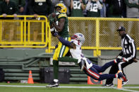 Green Bay Packers wide receiver Romeo Doubs looks to catch a pass ahead of New England Patriots cornerback Jonathan Jones, right, in the end zone during the second half of an NFL football game, Sunday, Oct. 2, 2022, in Green Bay, Wis. The pass was ruled incomplete. (AP Photo/Matt Ludtke)