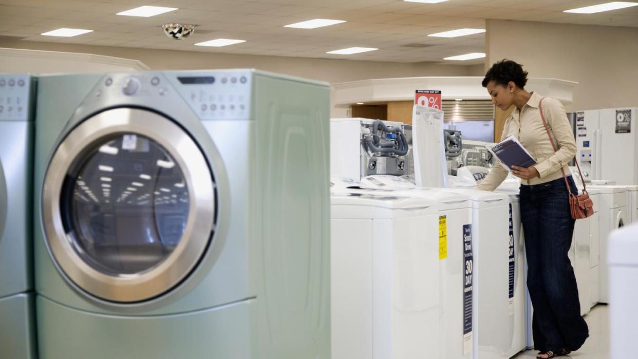 A woman looking at washing machines in showroom