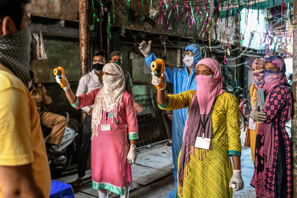 Health workers check residents' temperatures during a mass screening for COVID-19 symptoms in Dharavi in April.<span class="copyright">Atul Loke—Panos Pictures/Redux</span>