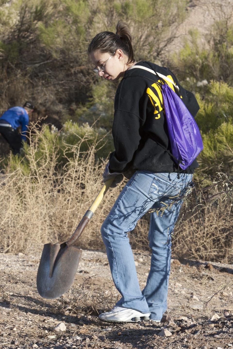 Marisol Parra of Tucson volunteers to remove buffelgrass at Julian Wash in Tucson.