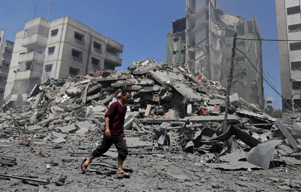 A man walks past the the rubble of the Yazegi residential building that was destroyed by an Israeli airstrike, in Gaza City, Sunday, May 16, 2021. The 57-member Organization of Islamic Cooperation held an emergency virtual meeting Sunday over the situation in Gaza calling for an end to Israel’s military attacks on the Gaza Strip. (AP Photo/Adel Hana)