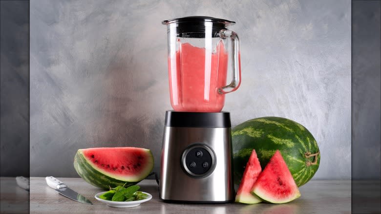 Watermelon in a blender next to watermelons