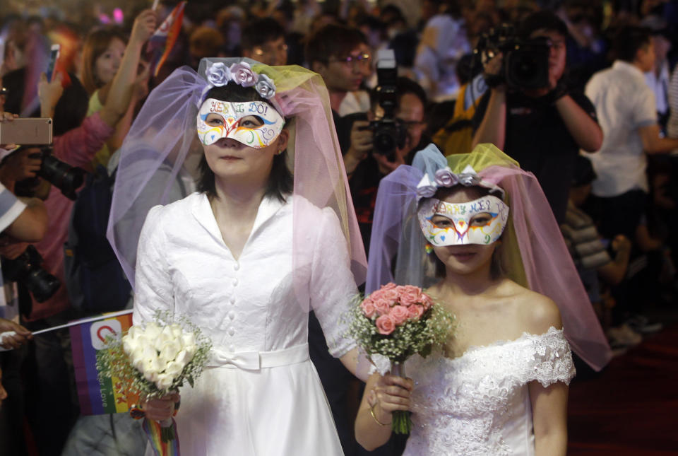 Taiwanese same-sex couples go red carpet at their wedding party in Taipei, Taiwan, Saturday, May 25, 2019. Taiwan became the first place in Asia to allow same-sex marriage last week. Hundreds of same-sex couples in Taiwan rushed to get married Friday, the first day a landmark decision that legalized same-sex marriage took effect. (AP Photo/Chiang Ying-ying)