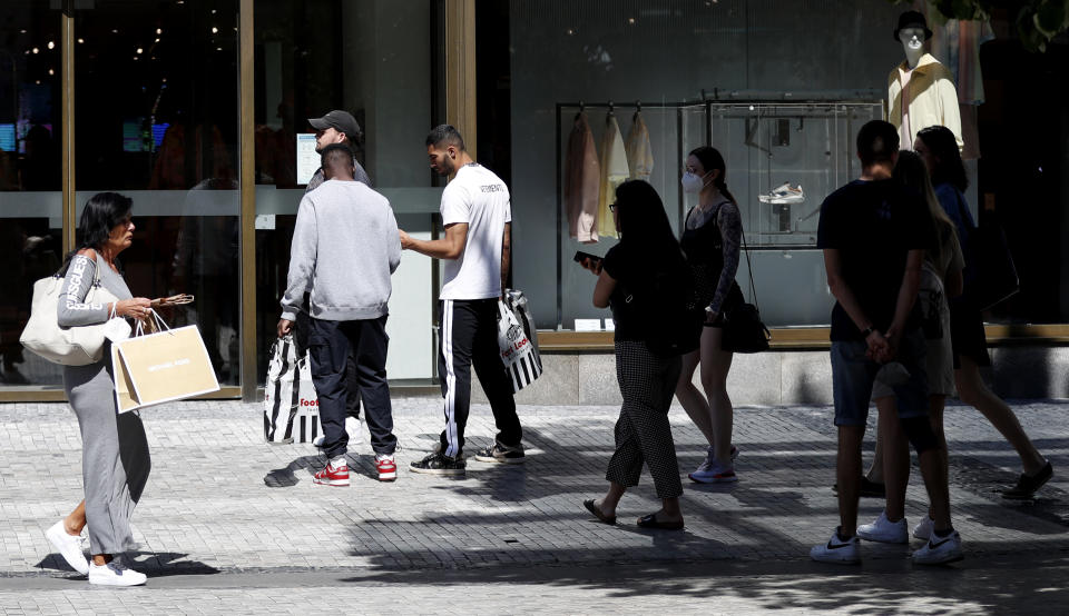 People wait in line in front of a shop in Prague, Czech Republic, Monday, May 10, 2021. The Czech Republic is massively relaxing its coronavirus restrictions as the hard-hit nation pay respect to nearly 30,000 dead. Monday's wave of easing came after the new infections fell to the levels unseen from August when the government failed to react in time to an opposite trend, the growing numbers of infected which later contributed to record numbers of deaths. (AP Photo/Petr David Josek)