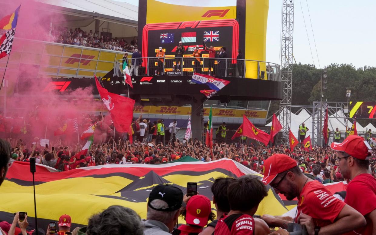 The Ferrari fans celebrate underneath the podium