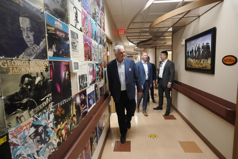 Nevada Gov. Steve Sisolak, center left, walks through a community center during a campaign event Tuesday, Nov. 8, 2022, in Las Vegas. (AP Photo/Gregory Bull)