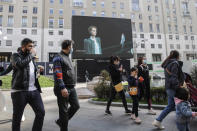 A giant screen streams a Giorgio Armani fashion live show presenting the women's Fall Winter 2021-22 collection, unveiled during the Fashion Week in Milan, Italy, Saturday, Feb. 27, 2021. (AP Photo/Luca Bruno)