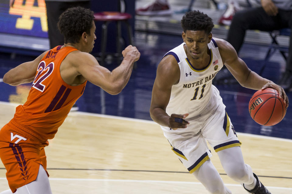 Notre Dame's Juwan Durham (11) drives in as Virginia Tech's Keve Aluma (22) defends during the first half of an NCAA college basketball game Wednesday, Jan. 27, 2021, in South Bend, Ind. (AP Photo/Robert Franklin)