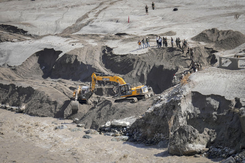 Indian army personnel dig sand along the Teesta river as they continue the search for those missing and to recover their vehicles in Bardang, east Sikkim, India, Sunday, Oct. 8. 2023. Rescuers continued to dig through slushy debris and ice-cold water in a hunt for survivors after a glacial lake burst through a dam in India’s Himalayan northeast, shortly after midnight Wednesday, washing away houses and bridges and forcing thousands to flee. (AP Photo/Anupam Nath)