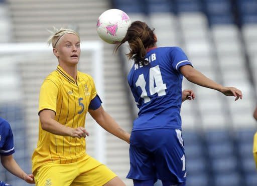 Sweden's Nilla Fischer (L) clashes with France's Louisa Necib (R) during a London 2012 Olympic Games women's football match at Hampden Park, Glasgow, Scotland. France won 2-1