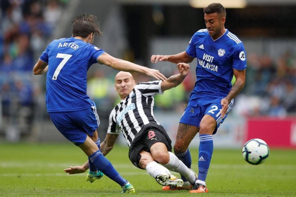 Drab affair: Shelvey battles for possession during the stalemate in Cardiff (REUTERS)