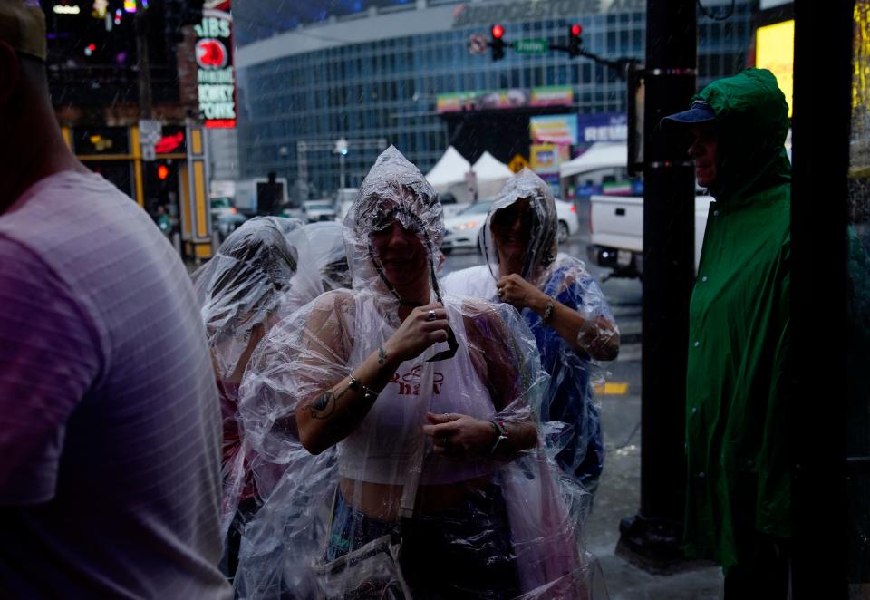 People on the street enter Legends Corner honky tonk as a heavy rain storm hit the area after the outdoor events had been cancelled earlier in the afternoon on the fourth day of CMA Fest in Nashville, Tenn., Sunday, June 11, 2023.