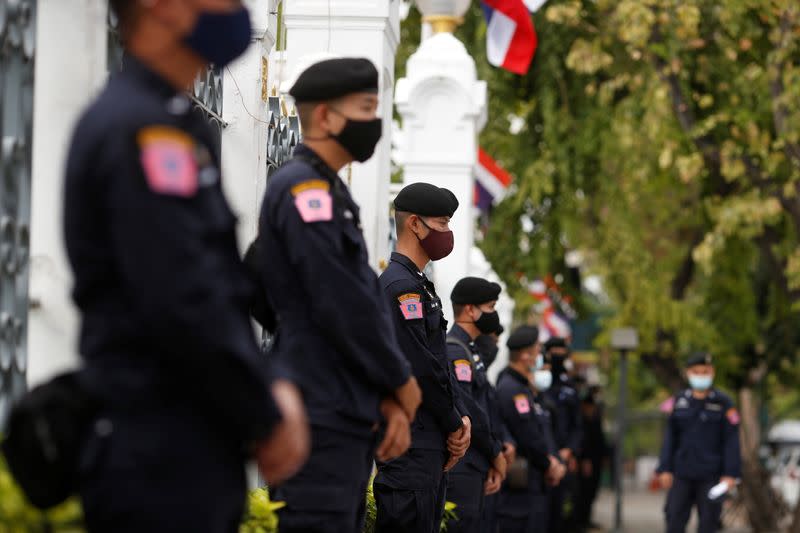 Police stand guard as anti government protesters try sell shrimps in front of government house amidst the COVID-19 outbreak in Bangkok