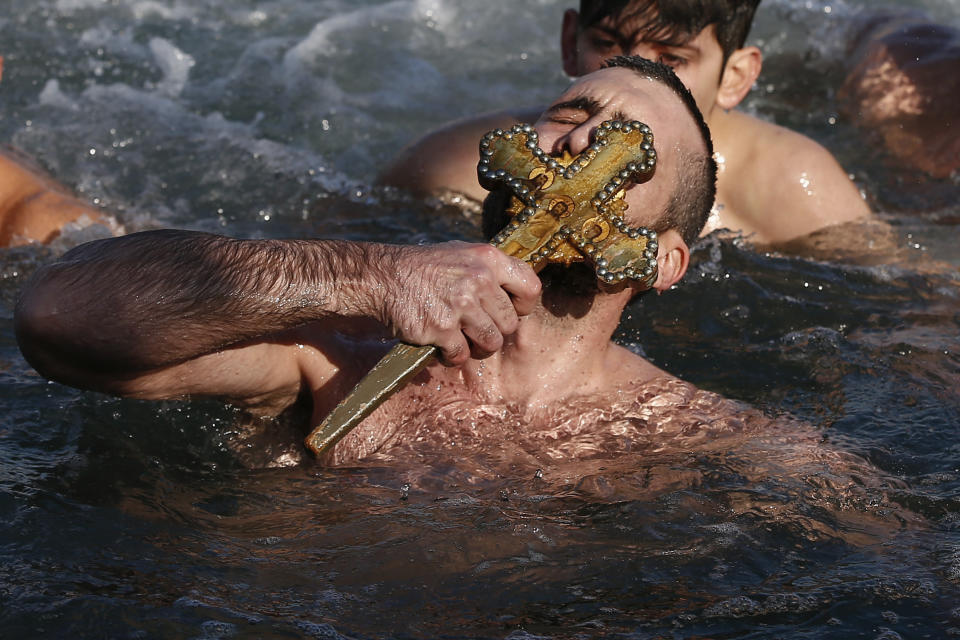 <p>Nicolaos Solis from Greece kisses the wooden cross which was thrown into the waters by Ecumenical Patriarch Bartholomew I, during the Epiphany ceremony to bless the waters at the Golden Horn in Istanbul, Saturday, Jan. 6, 2018. (Photo: Emrah Gurel/AP) </p>