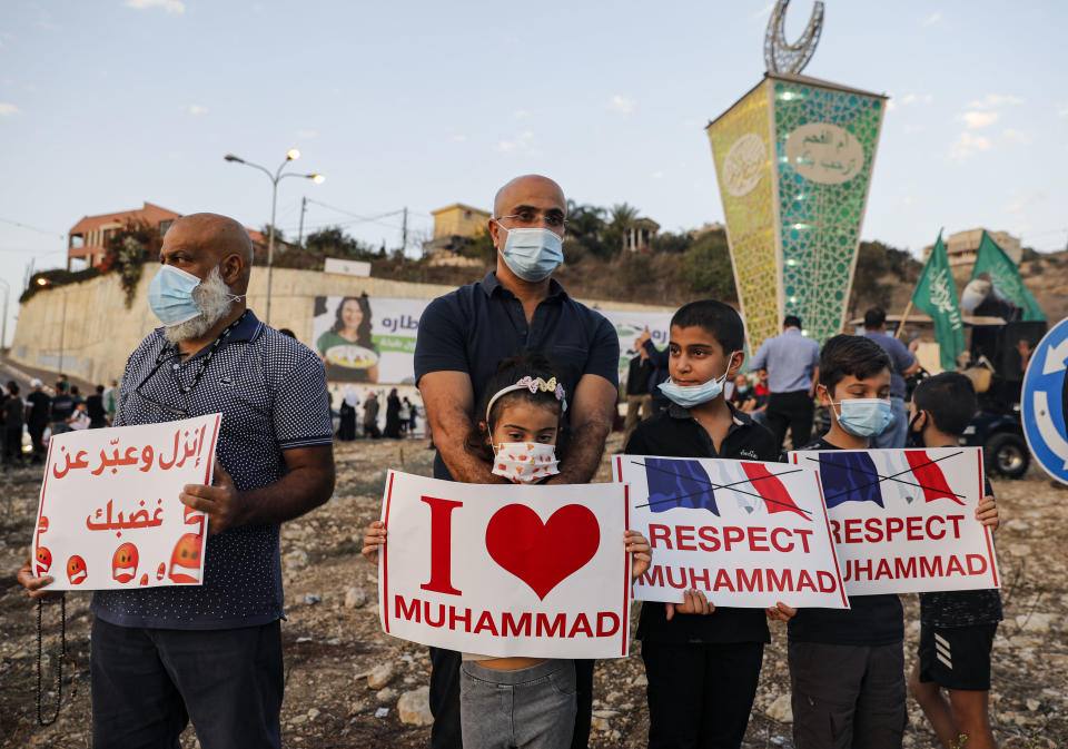 Arab Israeli Muslim demonstrators (including children), clad in masks due to the COVID-19 coronavirus pandemic, hold up signs as they gather for a rally protesting against the comments of French President Emmanuel Macron over Prophet Mohammed cartoons, in the Arab town of Umm-Al Fahem in Northen Israel on October 25, 2020. (Photo by Ahmad GHARABLI / AFP) (Photo by AHMAD GHARABLI/AFP via Getty Images)