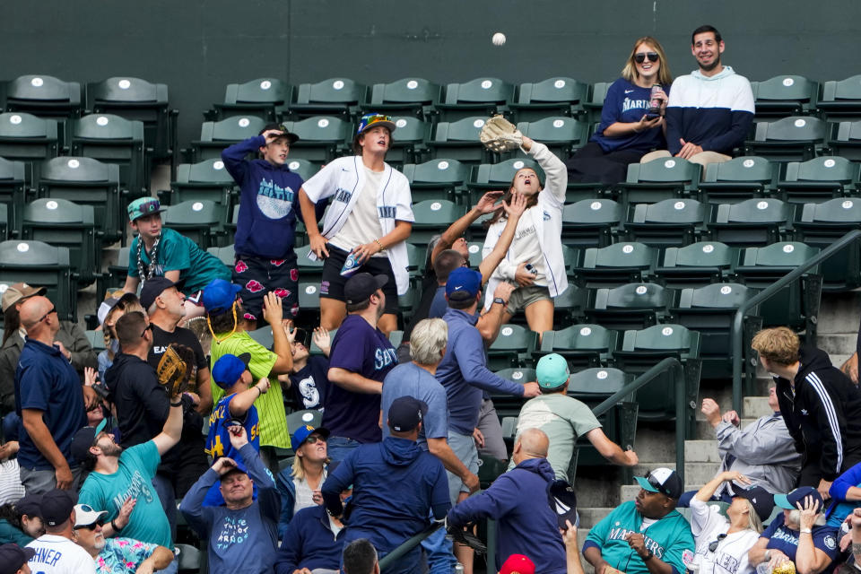 A fan catches the two-run home run ball from Oakland Athletics' Lawrence Butler against the Seattle Mariners during the second inning of a baseball game, Wednesday, Aug. 30, 2023, in Seattle. (AP Photo/Lindsey Wasson)