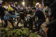 Varios manifestantes atacan a un agente que se quedó solo (AP Photo/Joan Mateu)