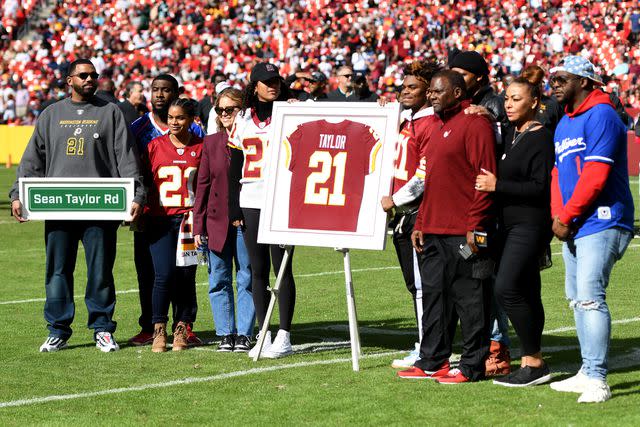 <p>Mitchell Layton/Getty Images</p> Family and friends of Sean Taylor gather during the retirement ceremony of Taylor's jersey at FedExField on October 17, 2021 in Landover, Maryland