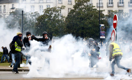 Protesters wearing yellow vests clash with riot police during a demonstration of the "yellow vests" movement in Nantes, France, January 12, 2019. REUTERS/Stephane Mahe