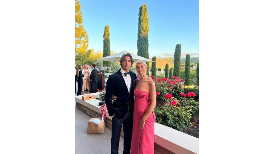 son posing in suit with mother