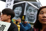 Protesters hold portraits of Hong Kong Chief Executive Leung Chun-ying (R) and resigned Chief Secretary Carrie Lam ahead of Leung's policy address, outside Legislative Council in Hong Kong, China January 18, 2017. REUTERS/Bobby Yip