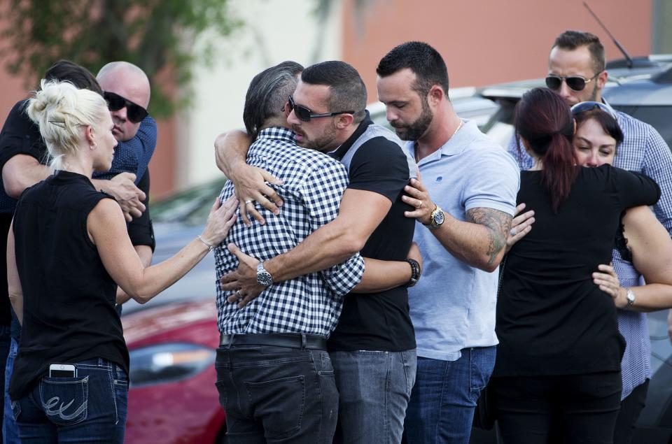 <p>Mourners embrace outside the visitation for a Pulse nightclub shooting victim, Javier Jorge-Reyes, in Orlando. (Photo: David Goldman/AP) </p>