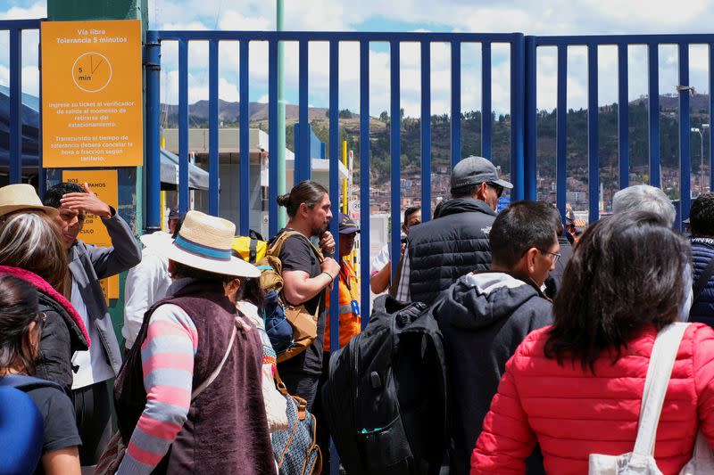 Passengers stand in line outside the airport, in Cuzco