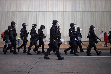 Police in riot gear march towards protestors, who were demanding justice for Michael Brown, near the Edward Jones Dome, the site of an NFL football game between the St. Louis Rams and the Oakland Raiders, in downtown St. Louis, Missouri in this November 30, 2014 file photo. REUTERS/Adrees Latif