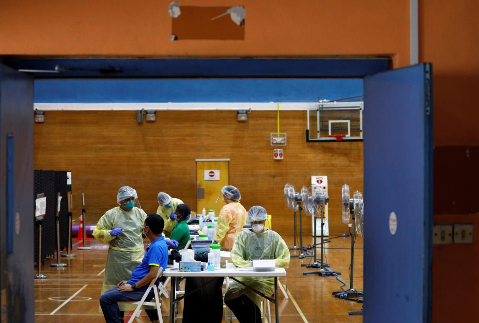 Essential workers have their noses swabbed before returning to the workforce at a regional screening center, amid the coronavirus disease (COVID-19) outbreak in Singapore June 10, 2020.   REUTERS/Edgar Su