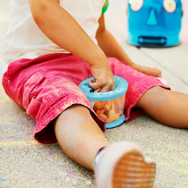 child sticking hand in snack cup