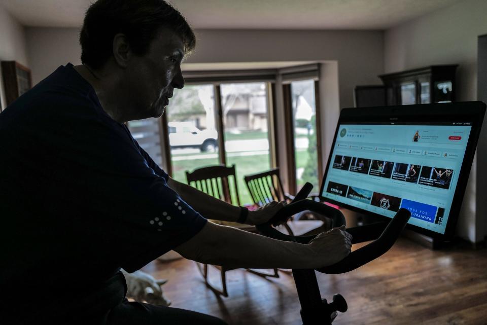 Rebekah Darnell uses a Peloton bike in her Okemos home Sunday, April 16, 2023, to ride virtually in the Braille Across America Virtual Challenge, which raises money for books and Braille education.